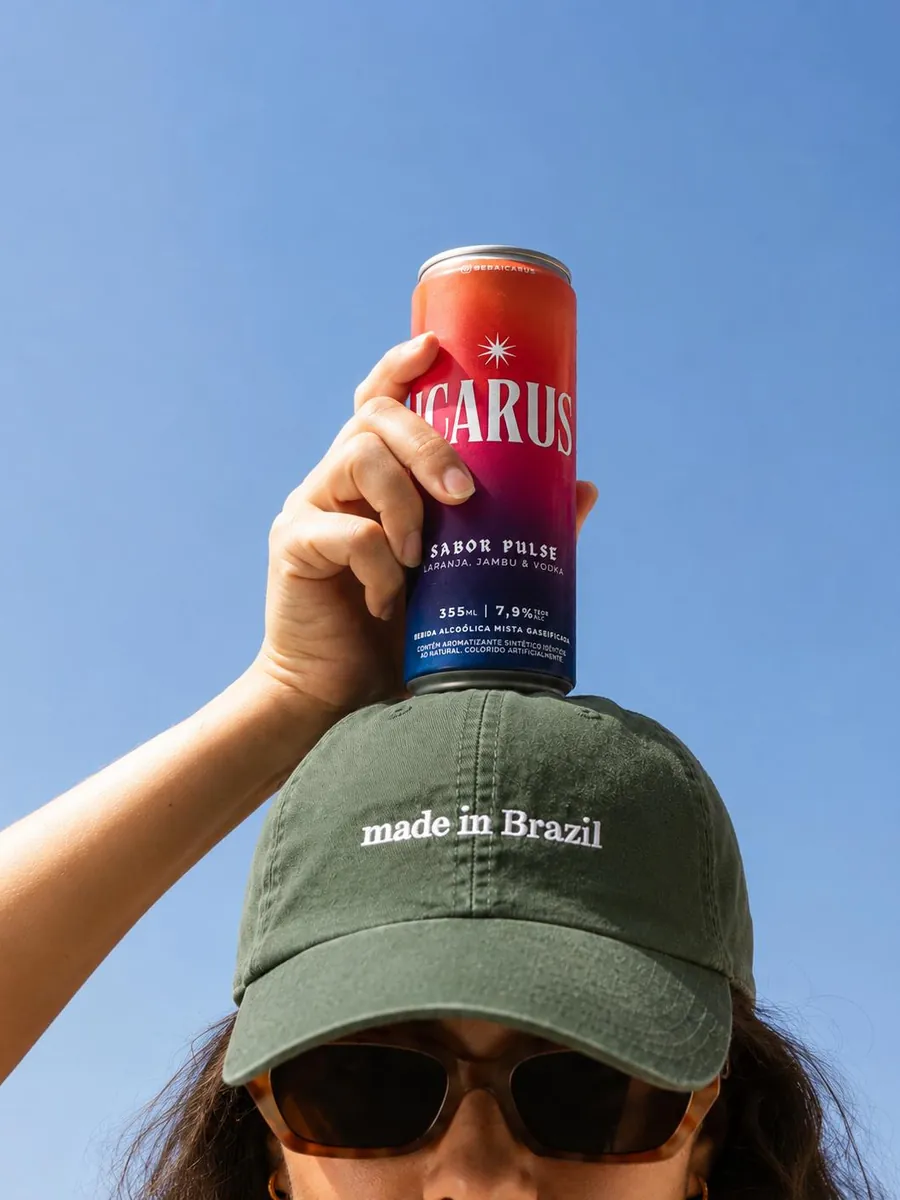 Pessoa de boné “made in Brazil” com uma lata de ICARUS na cabeça